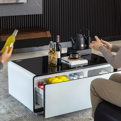 Mesa lateral de la sala de estar con mesa de café inteligente y minibar frigorífico privado del hotel Molde